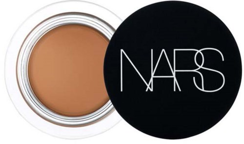 Ein kleiner Behälter mit beiger Creme und schwarzem Deckel mit weißem 'NARS'-Logo.