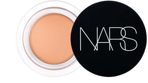 En liten burk med concealer med svart NARS-lock bredvid.
