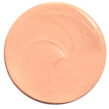 En rund, persikofärgad kräm eller lotion med en slät, blank yta.