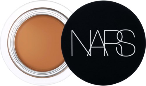 Ein runder Behälter mit beiger Foundation und schwarzem Deckel mit 'NARS' darauf.