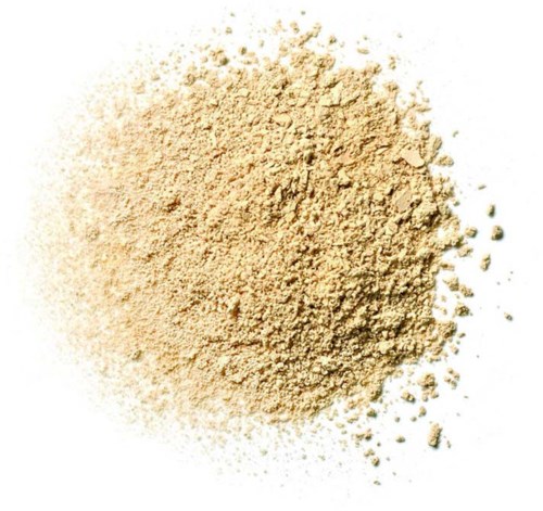En hög av beige pulver spridd på en vit bakgrund.