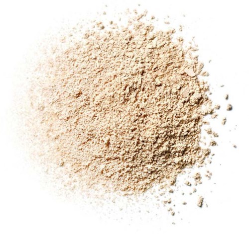 En hög av beige, pulvriskt material, spridd med små klumpar och partiklar runt den.