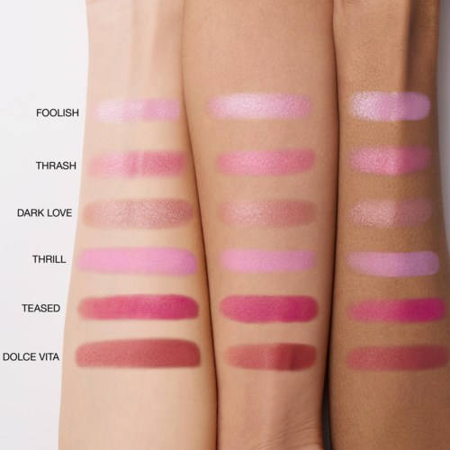 Swatches av leppestengenser på tre armer, merket med navn som Foolish, Thrash, Dark Love, Thrill, Teased, Dolce Vita.