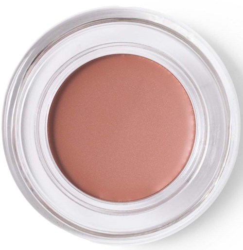 A round container with peach-colored cream or blush inside. The container is clear and simple.