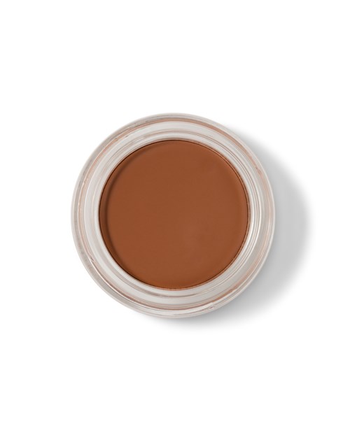 A small round container with brown makeup or cream inside, viewed from above on a white background.