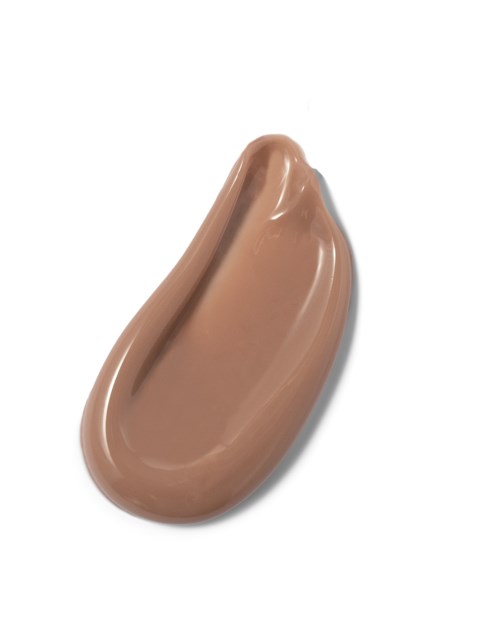 A smear of light brown creamy substance on a white background.