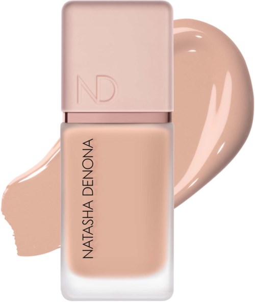 En flaska foundation i ljus beige färg, etiketten säger Natasha Denona, och en swatch av produkten bakom.