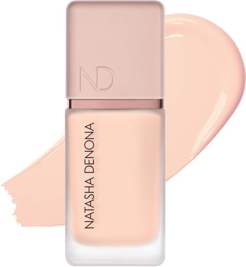 En ljus rosa nagellackflaska med ett mjukt rosa lock, med en färgprov av nagellack bakom.