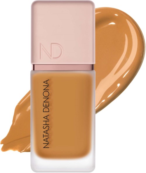 En foundationflaska med rosa lock och beige vätska, samt en prov på foundation bakom den.