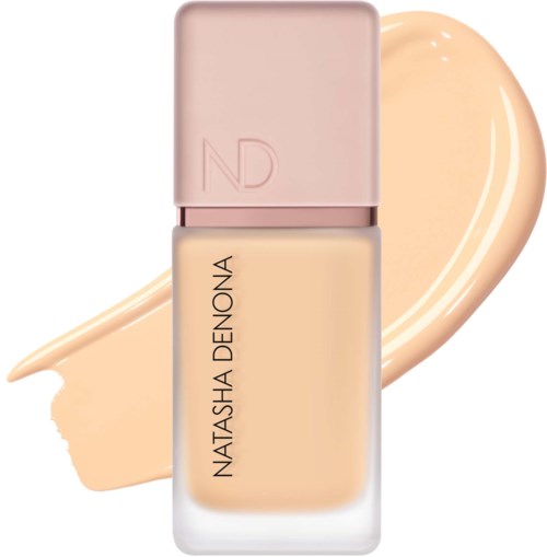 En flaska av Natasha Denona foundation med en beige färg och ljusrosa lock.
