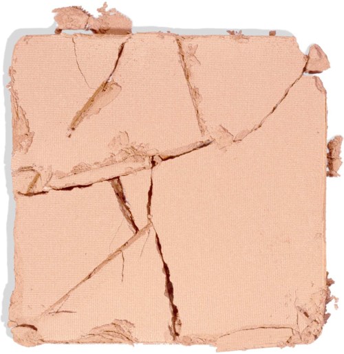 Trasig beige sminkpuder med stora sprickor och saknade bitar.
