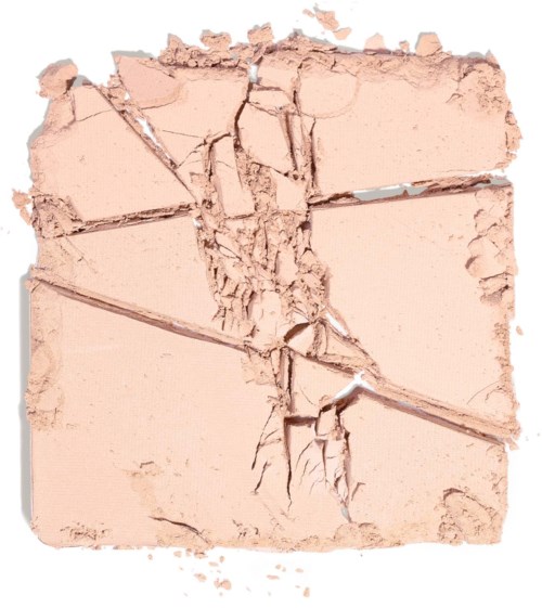 Trasig beige puder med sprickor och linjer, liknar en sprucken yta eller makeuppuder.
