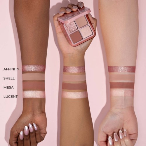 Swatchar av fyra glittrande makeupljus finns på tre armar, håller en palett som matchar nyanserna, mot en rosa bakgrund.