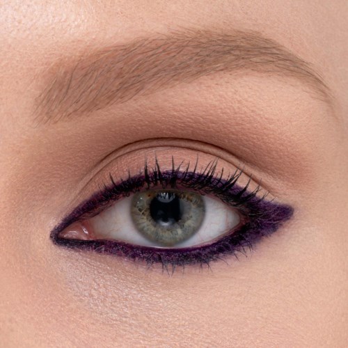 En närbild av en kvinnas öga med smink, inklusive lila eyeliner och långa ögonfransar.
