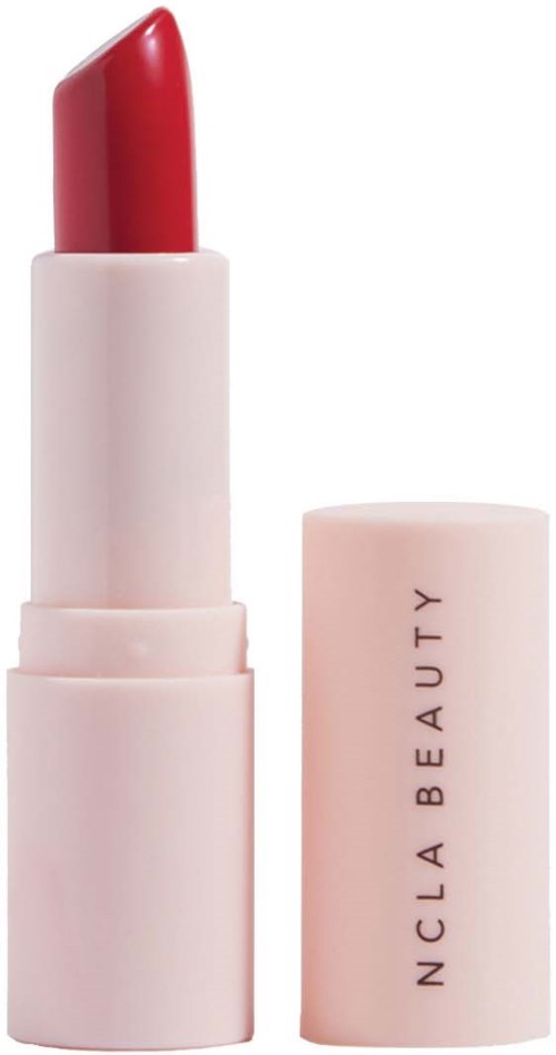 Et rødt leppestift i en lys rosa tube, med lokket ved siden av med teksten 'NCLA BEAUTY'.