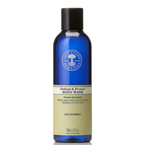 En blå flaska med svart lock märkt 'Neal's Yard Remedies' innehåller 'Defend & Protect Body Wash' som rengör och skyddar huden.