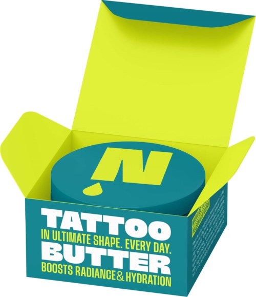 A round blue container of tattoo butter inside a bright yellow open box with green and white text.