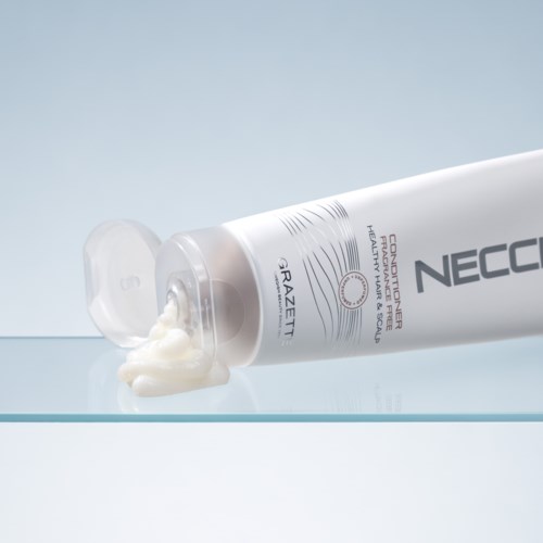 En tube med Neocut Forte-krem med noe krem som har rent ut på en glassflate.