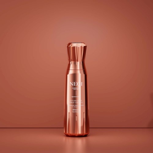 A rose gold cosmetic bottle stands on a surface with a matching background, reflecting light and displaying branding.