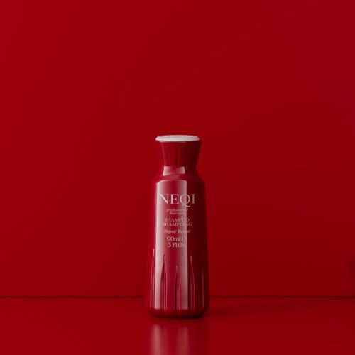 Red shampoo bottle with white text on a matching red background.
