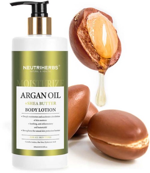 A body lotion bottle with a pump, surrounded by argan nuts and a half nut with oil flowing out.