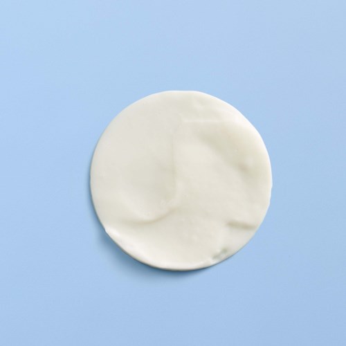 A round piece of white material, possibly fabric or paper, on a light blue background.