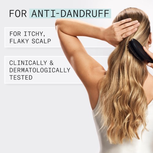 Texten beskriver en anti-dandruff-produkt för kliande, fjällig hårbotten, testad kliniskt och dermatologiskt. En kvinna använder en borste på sitt huvud.