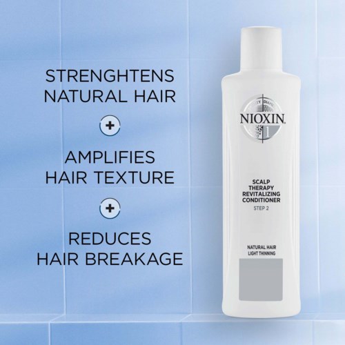 En vit flaska med skalpkonditioneringsbehandling på en blå kaklad vägg, som främjar hårstärkning, förtjockning och minskning av håravfall.