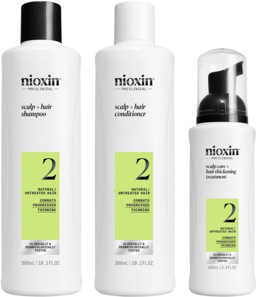 Tre vita flaskor med Nioxin hårvårdsprodukter med gröna etiketter; schampo, balsam och behandling för tunnare hår.