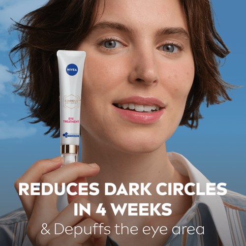 En kvinne holder en Nivea øyekrem, smilende, med tekst om å redusere mørke ringer på 4 uker.