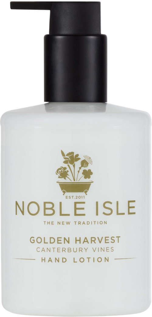 En hvid håndcremeflaske med sort pumpe, guldskrift og en plante logo. Den er mærket 'Noble Isle Golden Harvest.'