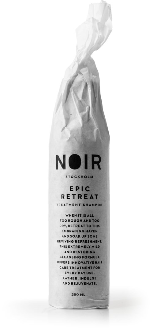 En vit schampoflaska med svart text, märkt 'NOIR STOCKHOLM EPIC RETREAT' och detaljerad beskrivning.