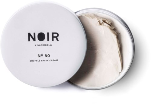 En vit behållare med Noir Stockholm soufflé-pastabak, med locket delvis öppet och visande den krämiga substansen inuti.
