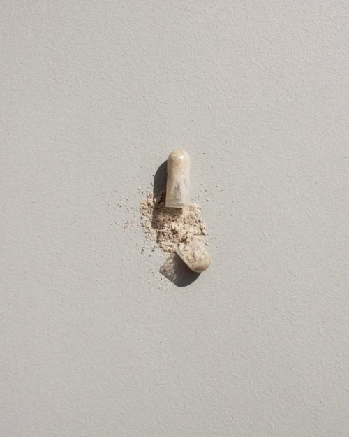 En termitt har spist opp deler av en hvit vegg, og det finnes et lite hull med rusk under.