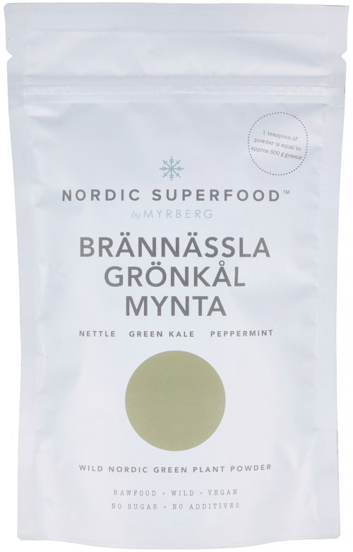 Hvit pose med blå snøfnugg, viser produktnavn og ingredienser som brennesle, grønnkål, peppermynte og naturlige, veganske.