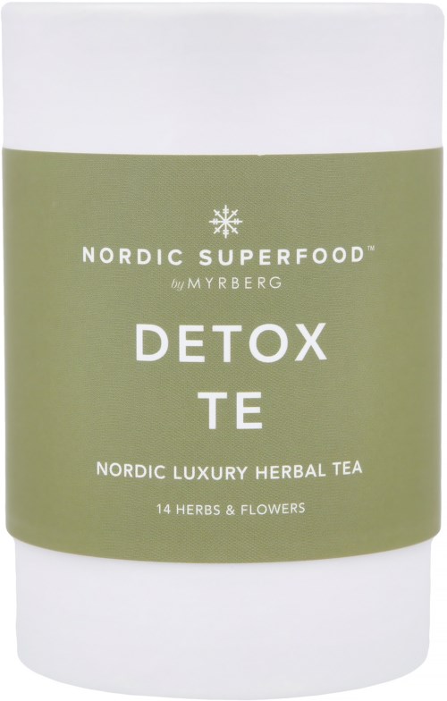 En hvid beholder med grøn label, der siger 'Detox Tea' og nævner urter og blomster til afgiftning.