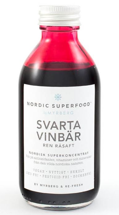 En liten flaske med mørk svart-rød væske, hvit lokk og etikett med tekst og blå stjerne.