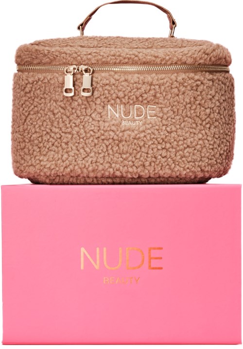 En koselig beige veske med håndtak og glidelåser på en rosa boks merket 'NUDE BEAUTY'.