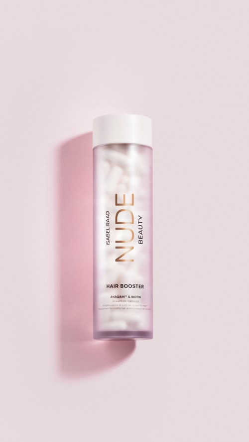 Skrzynka w kształcie cylindra z białą nakładką i przezroczystym korpusem, oznaczona 'Nude Beauty Hair Booster', na różowym tle.
