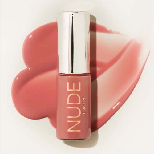 Nude rosa neglelakk fra Nude Beauty med sølvh Att, på en rosa kosmetisk søl.
