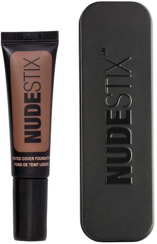 Nuudenvärinen meikkitiivistelaatikko ja musta suorakulmainen rasia, jossa on brändin nimi 'NUDESTIX'.
