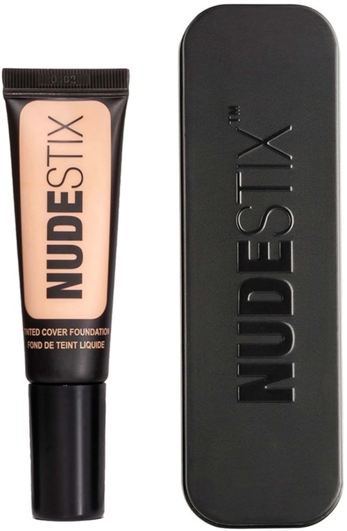Eine Tube NudeStix Foundation mit schwarzem Deckel und eine schwarze rechteckige Make-up-Box dahinter.