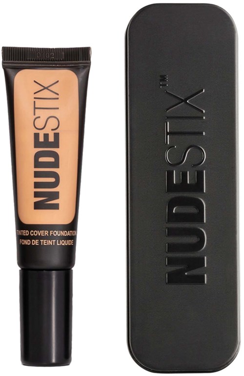 NudeStix-Foundation-Röhre und Metallbox sind zu sehen, beide schwarz mit prägtem Markennamen.