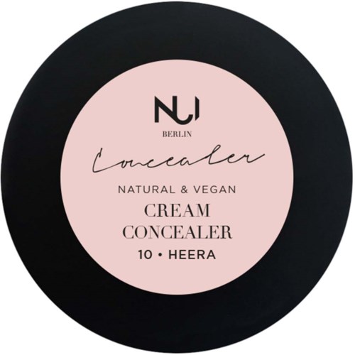 Concealer-beholder med lyserødt mærke. Den siger naturlig, vegansk, creme, concealer, 10, og Heera. Berlin-logo øverst.