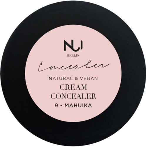 En rund sort beholder med en pink etikette, der står 'Concealer, naturlig og vegansk, cremetconcealer, 9 Mahuka, Berlin.'