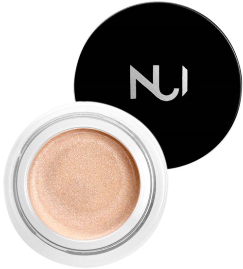 A small round container with shimmering beige makeup, and a black lid with a white logo.