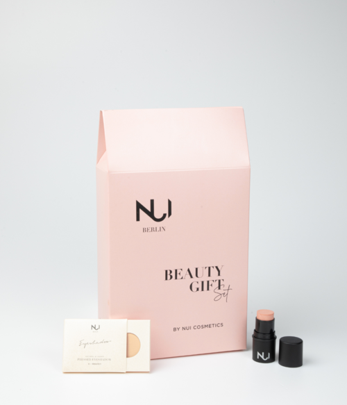 En rosa box med texten 'Beauty Gift', en liten behållare och ett kort framför lådan.