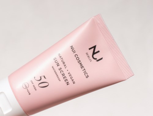 Pink tube of sun screen by NU Cosmetics, vegan and natural, SPF 50, water-resistant, for face.