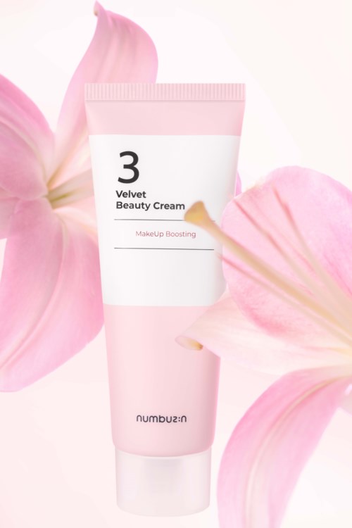 En rosa tub med Velvet Beauty Cream omgivet av rosa blommblad, med mjukt ljus och vit bakgrund.