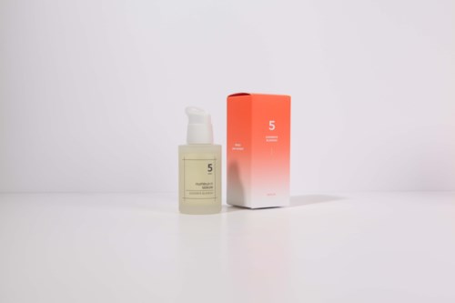 Een fles met pomp en een oranje doos ernaast, beide gelabeld met nummer 5.